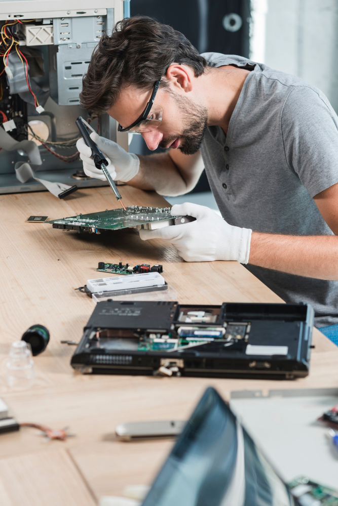 male-technician-repairing-computer-motherboard-wooden-desk